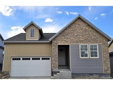Charming exterior of a two-story home featuring stone and siding, complete with an attached garage and inviting front entrance at 17075 W 92Nd Loop, Arvada, CO 80007
