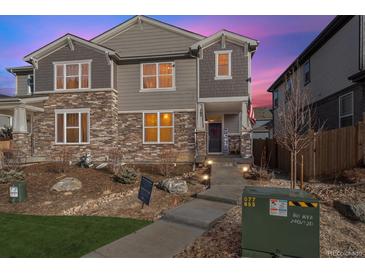 Charming two-story home featuring a stone and siding exterior with manicured landscaping at sunset at 765 N Shawnee St, Aurora, CO 80018