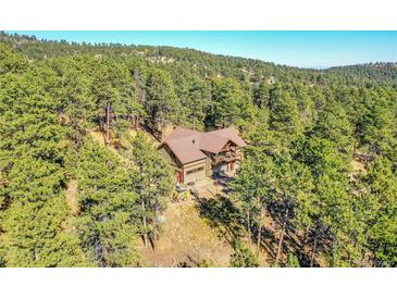 Secluded home nestled among the trees with a two-car garage and upper level deck at 24929 N Mountain Park Dr, Evergreen, CO 80439
