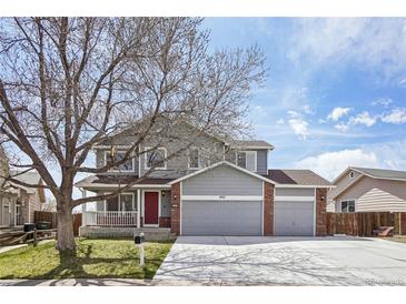 Charming two-story home with a manicured lawn, red door, and a spacious three-car garage at 882 W 96Th Ave, Thornton, CO 80260