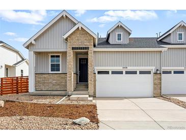 Charming townhome with a mix of stone and siding, complemented by a well-kept lawn and attached two-car garage at 3438 N Duquesne Way, Aurora, CO 80019