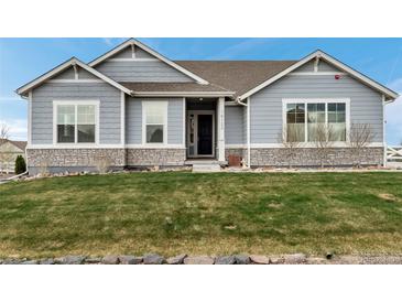 Charming single-story home with stone accents and manicured lawn at 16122 Emporia Way, Brighton, CO 80602