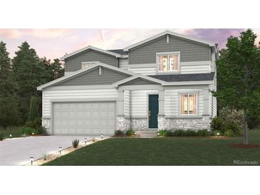 Two-story home with gray shingles, white siding, stone accents, manicured lawn, and an attached two-car garage at 1448 Orchard St, Brighton, CO 80601
