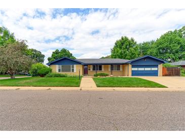 Charming brick home boasts a well-manicured lawn, blue trim, and an attached two car garage at 353 S Niagara St, Denver, CO 80224