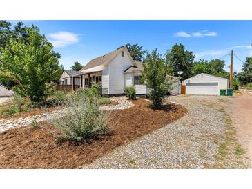 House exterior with gravel driveway and landscaping at 1111 E Dartmouth Ave, Englewood, CO 80113