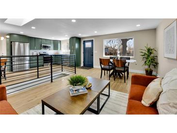Open-concept living space with modern decor, wood floors, and natural light from large windows at 10431 Holland St, Broomfield, CO 80021