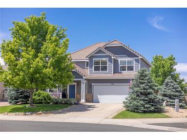 Charming two-story home featuring a well-manicured lawn, mature trees, and a two-car garage at 425 Peabody St, Castle Rock, CO 80104