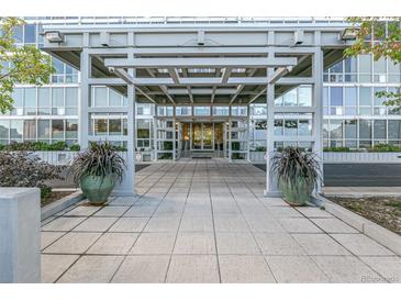 Inviting building entrance with tiled walkway, large potted plants, and a modern canopy at 3100 E Cherry Creek South Dr # 303, Denver, CO 80209