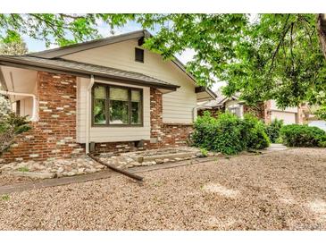 Charming home featuring mixed brick and siding, complemented by gravel landscaping and mature trees at 1665 W 113Th Ave, Denver, CO 80234