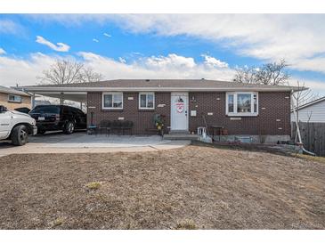 Charming brick home featuring a spacious carport and a well-manicured lawn on a sunny day at 2562 E 90Th Pl, Thornton, CO 80229