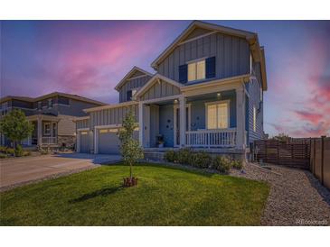 Charming two-story home with a well-manicured lawn and inviting front porch, showcasing its curb appeal at twilight at 10 N Quantock St, Aurora, CO 80018