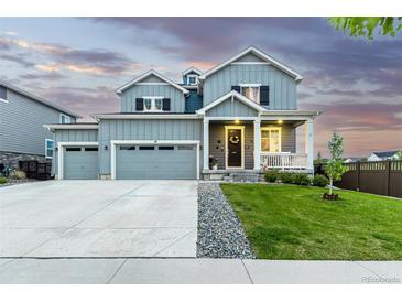 Charming two-story home with a well-manicured lawn, a cozy front porch, and a three-car garage at 10 N Quantock St, Aurora, CO 80018