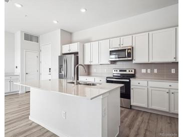 Modern kitchen with stainless steel appliances, white cabinetry and quartz countertops at 487 Interlocken Blvd # 410, Broomfield, CO 80021