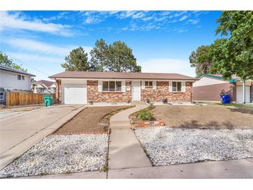 Charming brick home featuring a landscaped front yard with a walkway and freshly planted flower beds at 11976 E Arizona Dr, Aurora, CO 80012
