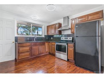 This well-lit kitchen features wood cabinets, stainless steel appliances, and granite countertops at 11976 E Arizona Dr, Aurora, CO 80012