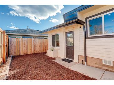 Charming front entrance with modern door, clean landscaping, and fenced yard for privacy at 4835 Grove St, Denver, CO 80221