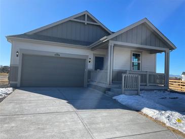 Charming one-story home with a gray garage door, covered porch and a well-maintained front yard at 16552 E 109Th Ave, Commerce City, CO 80022