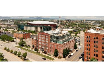 Stunning exterior view of a brick building with a modern glass rooftop addition, set against a vibrant cityscape backdrop at 1143 Auraria Pkwy # 203, Denver, CO 80204