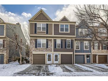 Two-story townhome with attached garage and snow-covered driveway at 8160 S Fillmore Cir, Centennial, CO 80122