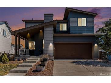 Charming two-story home featuring a covered front porch and a two-car garage at 10796 Truckee Cir, Commerce City, CO 80022