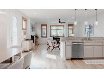 Bright, open-concept living room with wood floors and many large windows at 2034 Newton St, Denver, CO 80211