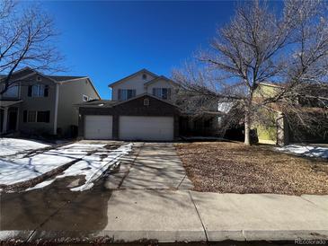 Two-story home with attached two-car garage and a partially snow-covered front yard at 11383 Oakland Dr, Commerce City, CO 80640