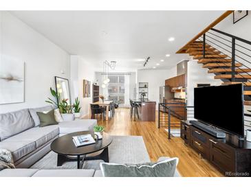 Bright and airy living room features modern decor, hardwood floors, and an open floor plan leading to the kitchen at 2706 Blake St, Denver, CO 80205