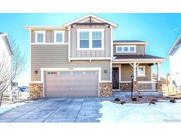 Two-story house with gray siding, stone accents, and a two-car garage at 27192 E Frost Pl, Aurora, CO 80016