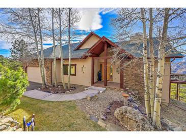 Inviting exterior of a stone and stucco home with a landscaped yard and wood accents at 2433 Dogie Spur, Golden, CO 80403