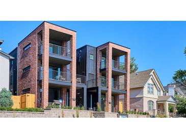 Modern townhomes featuring brick and metal accents, multiple balconies, and stone retaining walls at 1819 N Grove St, Denver, CO 80204