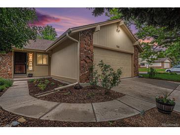 Charming home exterior features a two-car garage with stone accents and landscaped yard at 7582 S Newport Ct, Centennial, CO 80112