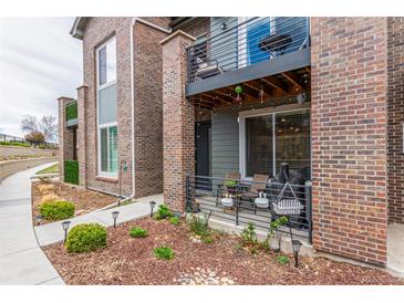 Charming townhome featuring a patio, second story balcony, and landscaped flower beds in front at 5187 S Fairplay St, Aurora, CO 80015