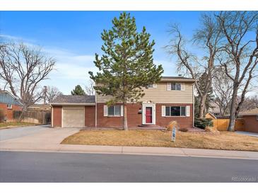 Charming two-story home with brick accents, a well-manicured lawn, and mature trees at 6940 S Uinta St, Centennial, CO 80112