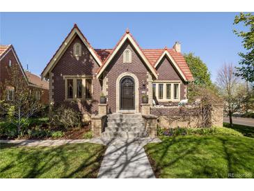 Charming brick home with a red-tiled roof and landscaped front yard in a neighborhood setting at 2591 Albion St, Denver, CO 80207