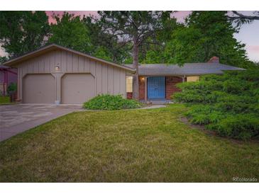 Charming home with a well-maintained lawn, two-car garage, and inviting blue front door at 2648 S Wadsworth Way, Lakewood, CO 80227