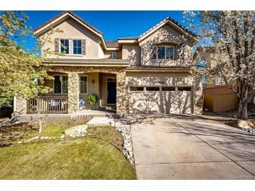 Inviting two-story home featuring a stone-accented porch, attached two-car garage, and mature landscaping at 4968 Montvale Dr, Highlands Ranch, CO 80130