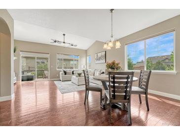 Bright dining area with hardwood floors, natural light and open floor plan to living area and outdoor patio at 19382 Dunraven St, Parker, CO 80134