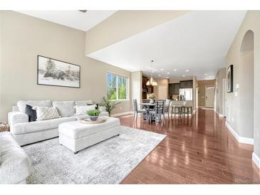 Bright open-concept living room and kitchen area with hardwood floors and neutral decor at 19382 Dunraven St, Parker, CO 80134