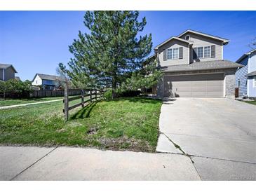 Two-story home features a two-car garage, fenced yard, and mature landscaping at 11191 W Crestline Dr, Littleton, CO 80127