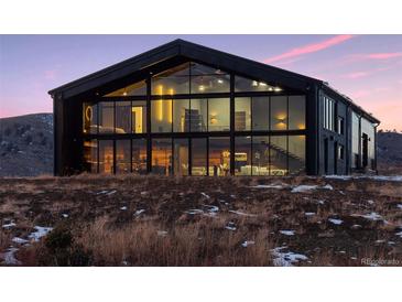 Stunning modern home with floor-to-ceiling windows showcasing the architectural design and expansive views at 6502 & 6200 Kiva Ridge Dr, Berthoud, CO 80513