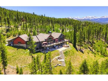 Expansive mountain home boasts a large deck, stone patio, and scenic mountain views at 1279 Estates Dr, Breckenridge, CO 80424