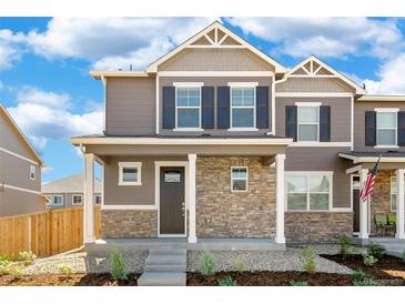 Two-story townhome with stone accents and a landscaped front yard at 22345 E 6Th Ave, Aurora, CO 80018