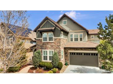 Charming two-story home featuring stone accents, an attached garage, and a well-manicured front yard at 10492 Willowwisp Way, Highlands Ranch, CO 80126