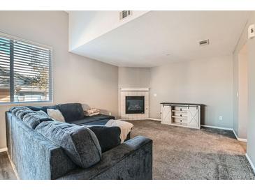 Cozy living room featuring a fireplace and a large comfortable sectional couch with lots of pillows at 2900 Purcell St # I4, Brighton, CO 80601