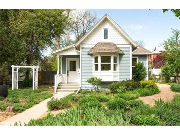 Charming home with light blue siding, well-manicured landscaping, and a welcoming front porch at 539 Baker St, Longmont, CO 80501