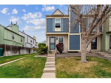 Charming townhome exterior featuring blue siding, a well-maintained lawn, and mature trees in a Gathering-friendly neighborhood at 1612 S Idalia Cir # A, Aurora, CO 80017