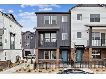 Charming two-story townhome with brick accents, a fenced yard, and a private balcony on the second floor at 6834 Merseyside Ln, Castle Pines, CO 80108