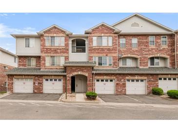 Charming townhouse featuring red brick, individual garages, and well-maintained landscaping at 8944 Fox Dr # 203, Thornton, CO 80260