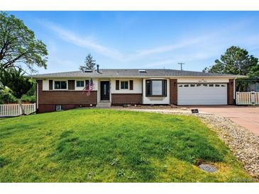 Charming ranch-style home with brick accents, well-manicured lawn, and attached two-car garage at 1818 South Union Ct, Lakewood, CO 80228