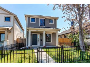 Charming gray two-story home with a black wrought iron fence and manicured front yard at 3346 N Josephine St, Denver, CO 80205